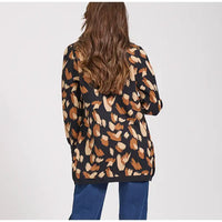 Person wearing a patterned cardigan with a plain background