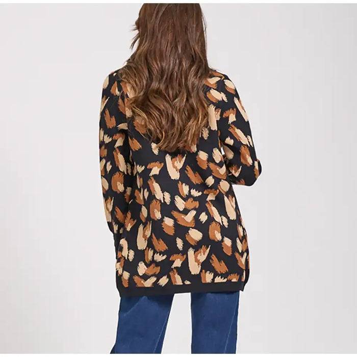 Person wearing a patterned cardigan with a plain background