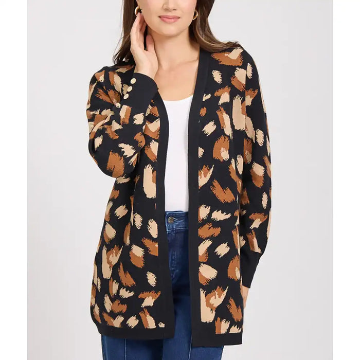 Woman wearing a patterned cardigan with a white top and blue jeans on a light gray background