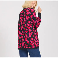 Woman wearing a black cardigan with pink floral pattern on a white background