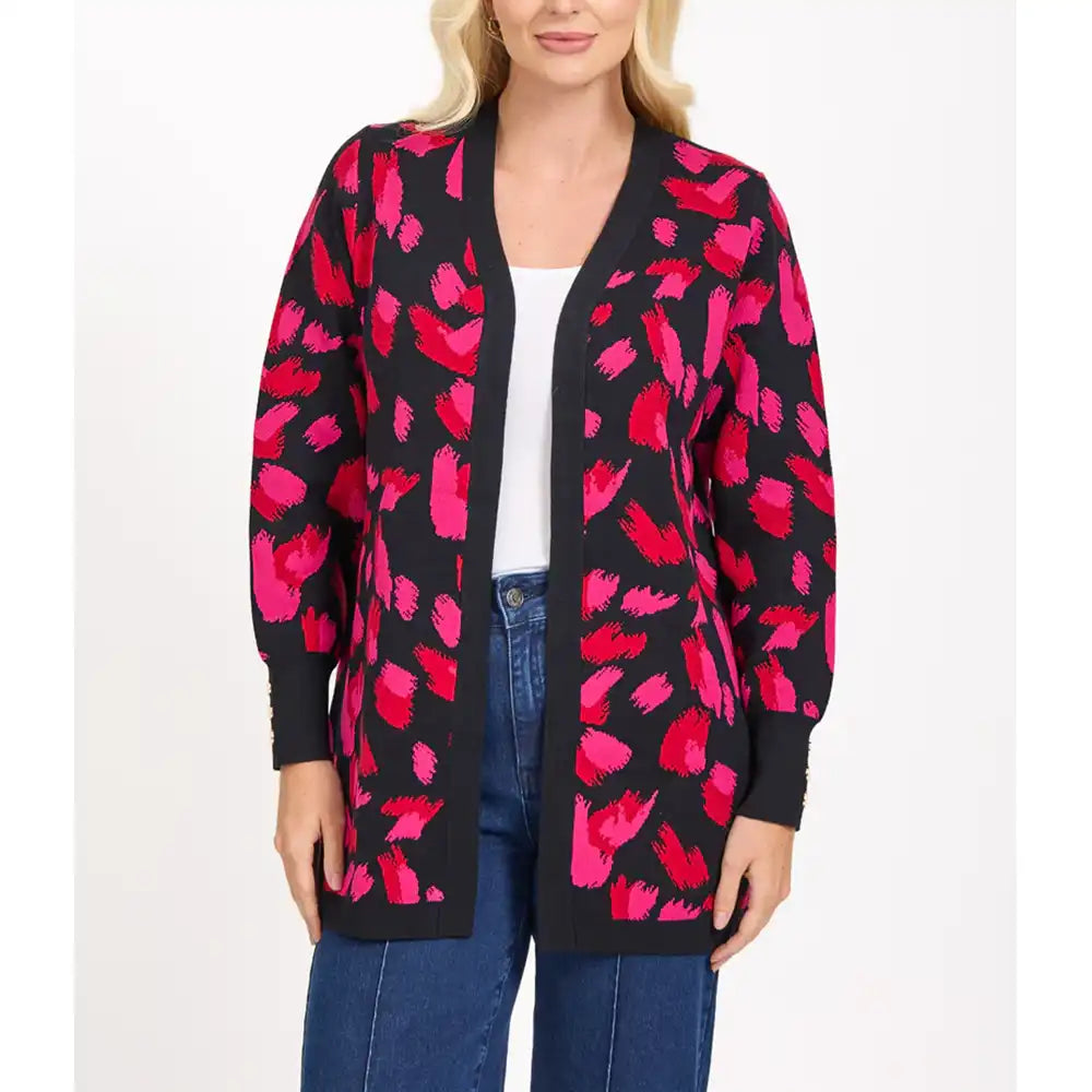 Woman wearing a black cardigan with pink floral pattern on a white background