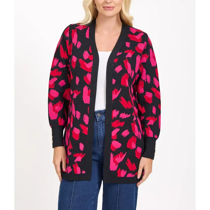 Woman wearing a black cardigan with pink floral pattern on a white background