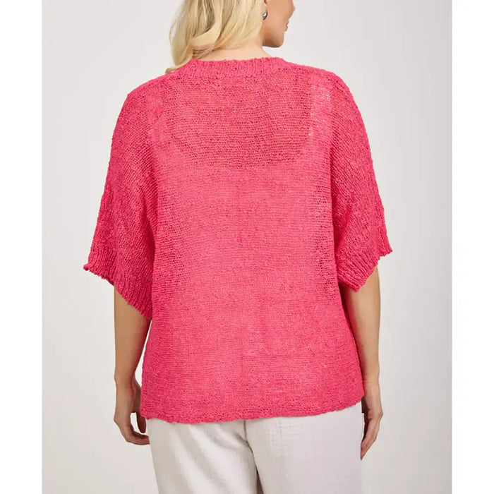 Person wearing a bright pink textured top against a plain background