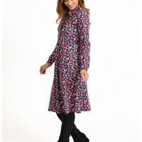 Woman wearing a colorful floral dress on a white background