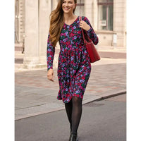 Woman in a floral dress walking on a city street