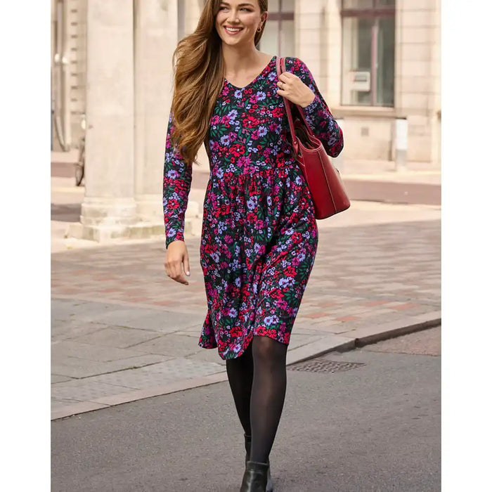 Woman in a floral dress walking on a city street
