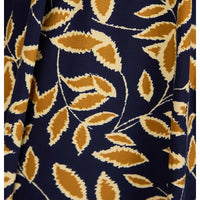 A close-up of a navy blue fabric with a repeating pattern of mustard yellow and cream leafy vines.