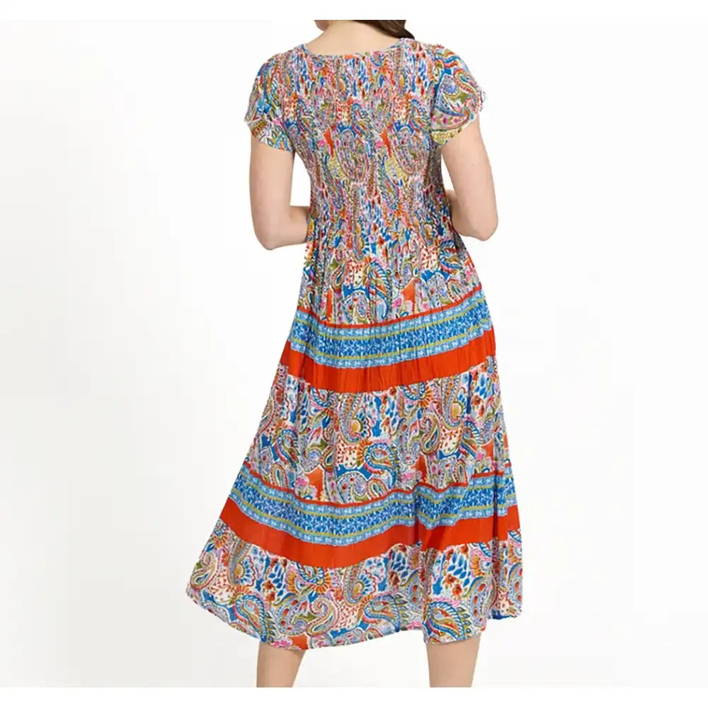 A woman modeling a short-sleeved midi dress from the back, featuring a colorful paisley pattern with prominent orange-red horizontal stripes, set against a plain white background.