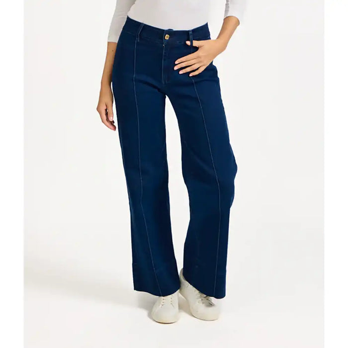 Navy blue flared jeans worn by a person on a white background