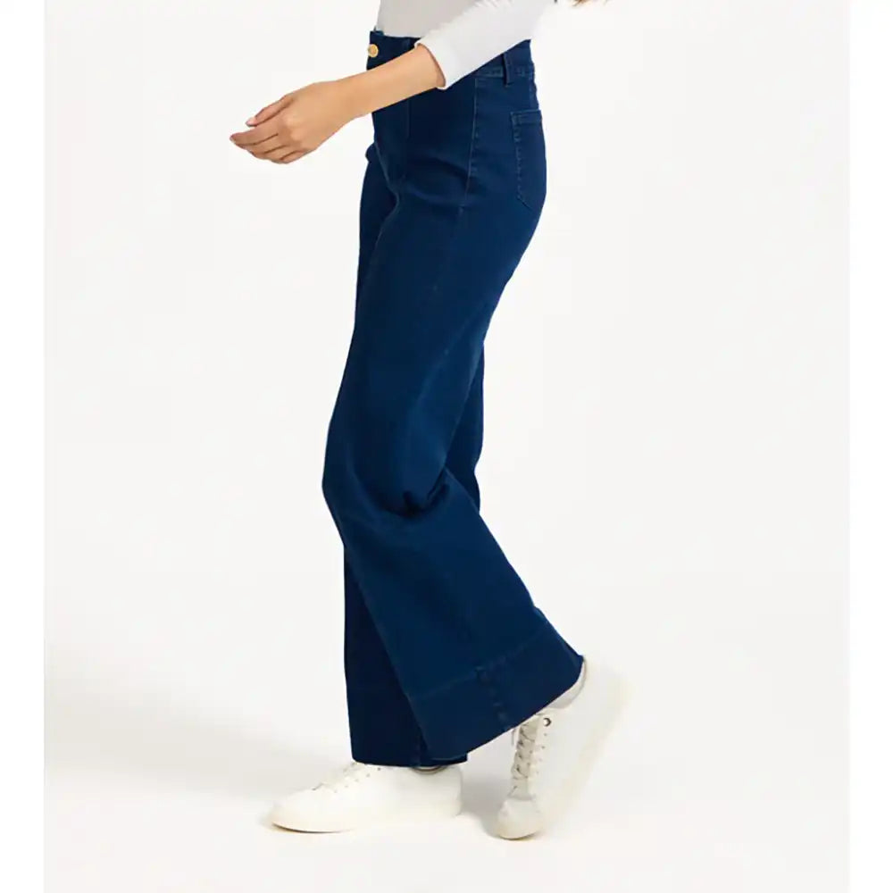 Person wearing blue flared pants on a white background