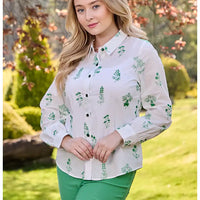 Front of a long sleeve white shirt. Shirt collar and green buttons on the front for fastening. Green floral embroidery all over. 