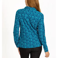 A woman viewed from the back wearing a long-sleeve collared blouse with an allover abstract leaf-like pattern in bright teal, turquoise, and blue tones, paired with black pants against a plain white studio background.