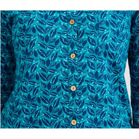 A close-up of a long-sleeve button-up shirt featuring a teal and navy blue leaf pattern, with four visible wooden buttons down the front.