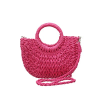 Fuchsia pink straw bag with a rounded straw covered handle . 