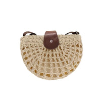 Woven handbag with a brown leather strap on a white background
