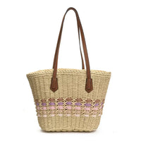 Woven straw bag with brown handles on a white background
