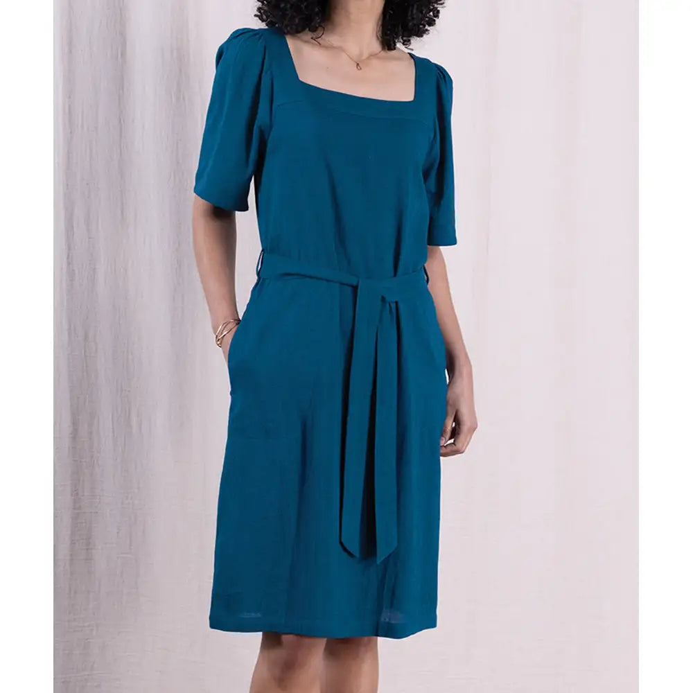 Teal dress with a belt on a plain background