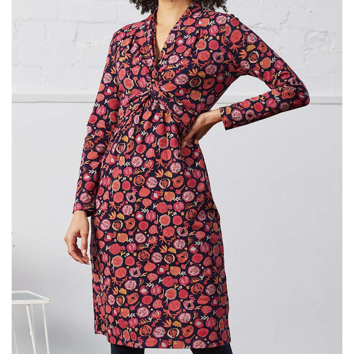 Nomads vegetables print jersy dress. Pinks on a navy blue background. Knee length. Front view.