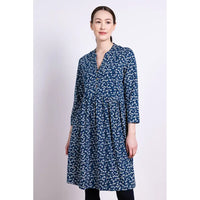 Woman wearing a blue floral tunic dress against a white background