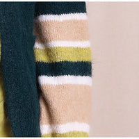 Close-up of a striped knit garment showing horizontal bands of dark teal, beige, olive green, and white, with a solid dark teal fuzzy trim.