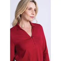 Woman wearing a red collared top with 2 buttons against a white background