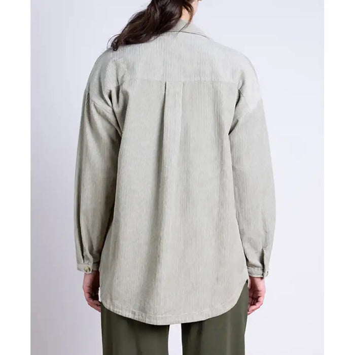 Person wearing a light green shirt with long sleeves on a white background