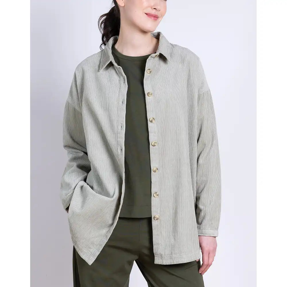 Person wearing a light gray button-up shirt over a green outfit on a white background