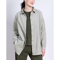 Person wearing a light gray button-up shirt over a green outfit on a white background