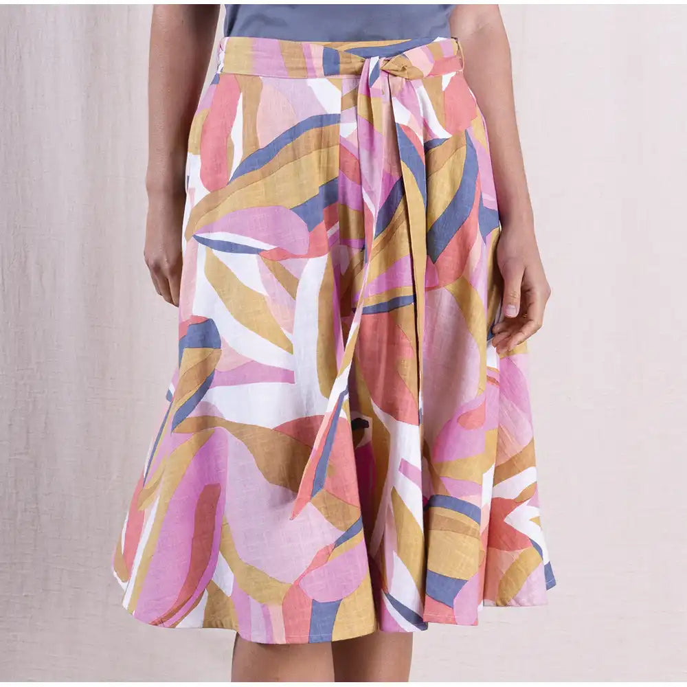 Colorful patterned skirt worn by a person on a plain background