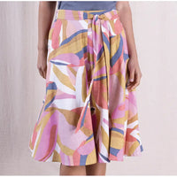 Colorful patterned skirt worn by a person on a plain background