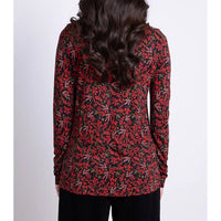Person wearing a red and black floral long-sleeve top on a white background