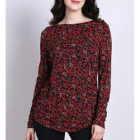 Woman wearing a red and black floral patterned top on a white background