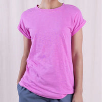Person wearing a pink t-shirt against a plain background