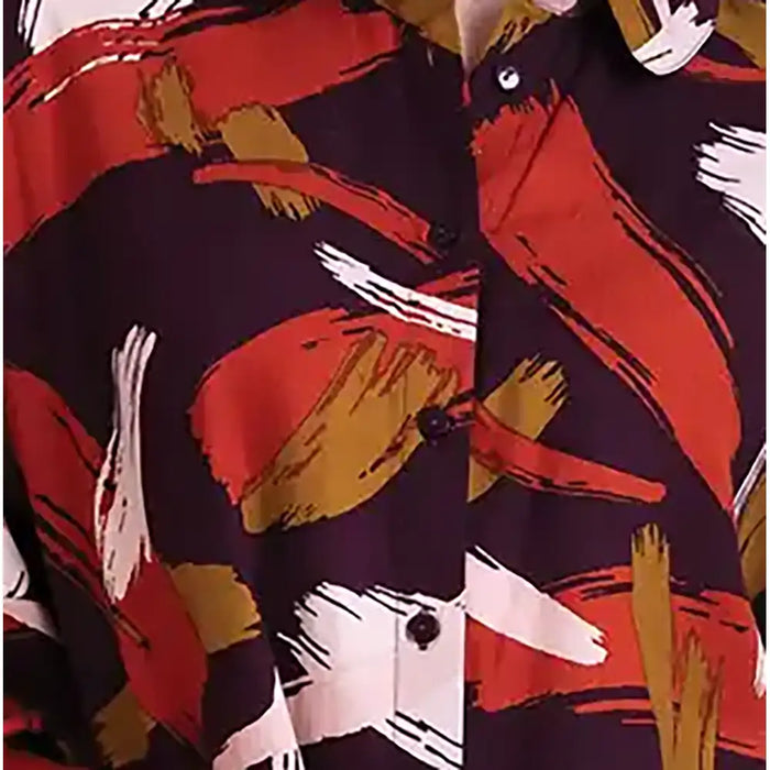 A close-up of a button-up shirt featuring an abstract brushstroke pattern in red, mustard yellow, white, and black.