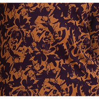 A close-up of a fabric pattern featuring an abstract, organic floral or leaf-like print in dark purple and warm brown.