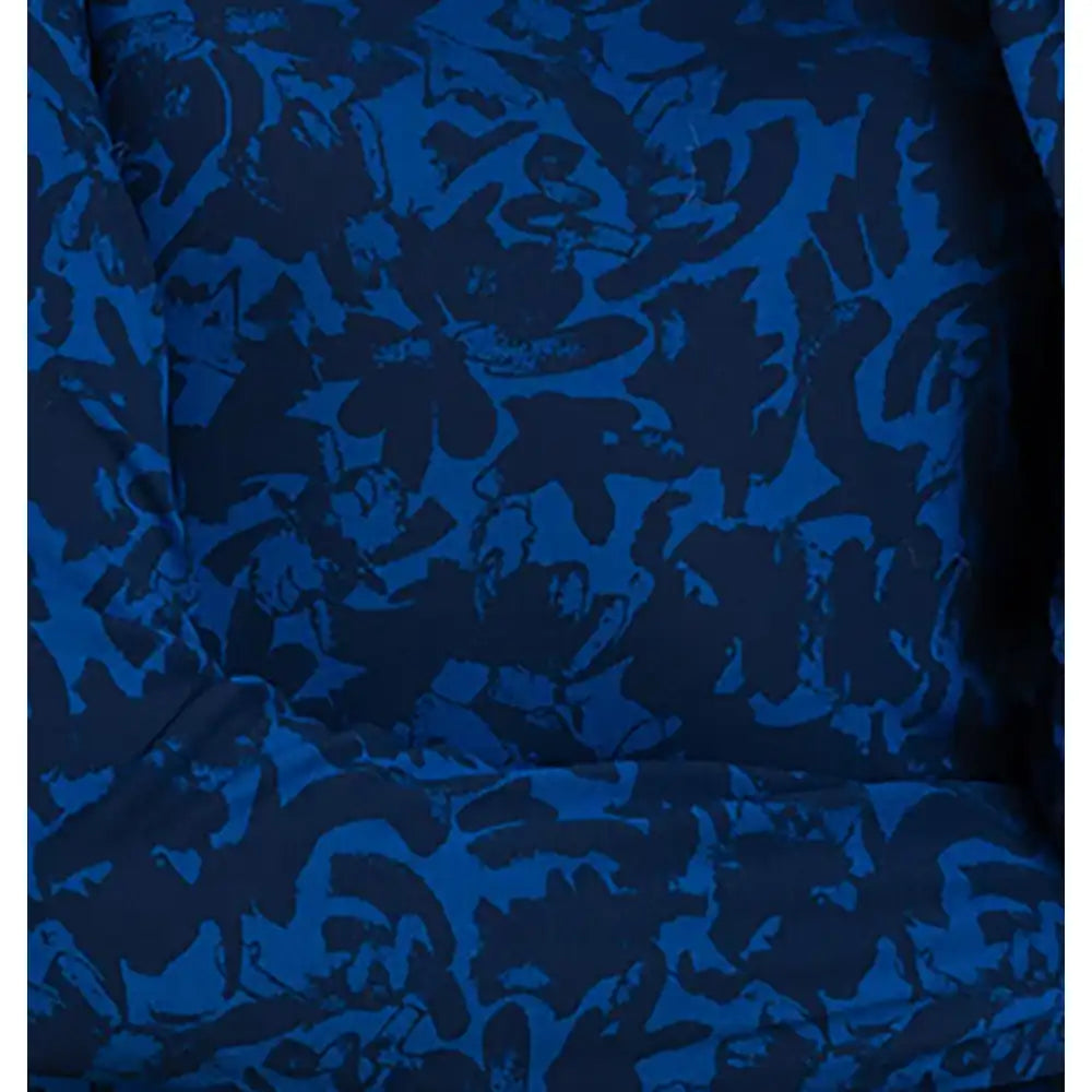 A close-up of a blue and navy floral jacquard fabric with an abstract, tonal pattern.