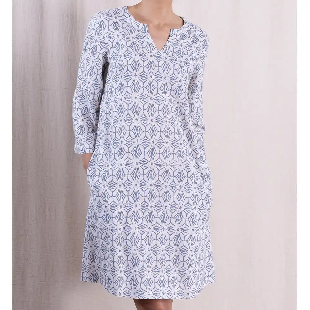 White dress with blue geometric pattern on a neutral background