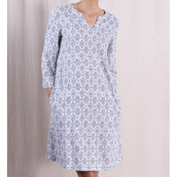 White dress with blue geometric pattern on a neutral background