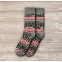 Pair of gray and pink patterned socks on a wooden surface