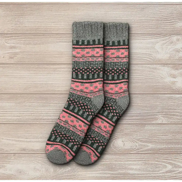 Pair of gray and pink patterned socks on a wooden surface