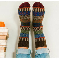 Colorful patterned socks worn with light blue jeans on a white background