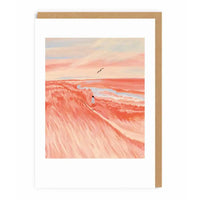 Framed artwork of a desert landscape with a winding road and a person, set against a pink and orange sky.