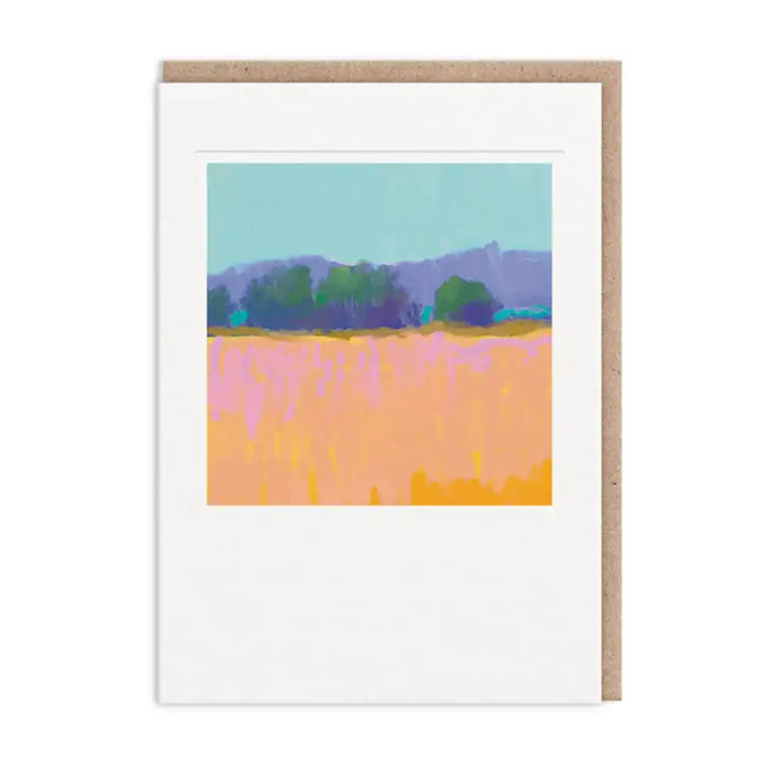 A white greeting card with a kraft brown envelope behind it, featuring a colorful abstract landscape painting of a field and trees.