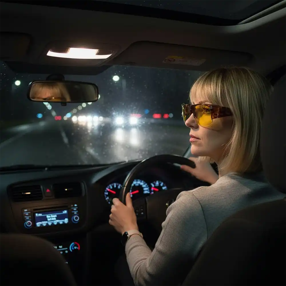 Woman driving a car wearing night sight glasses.
