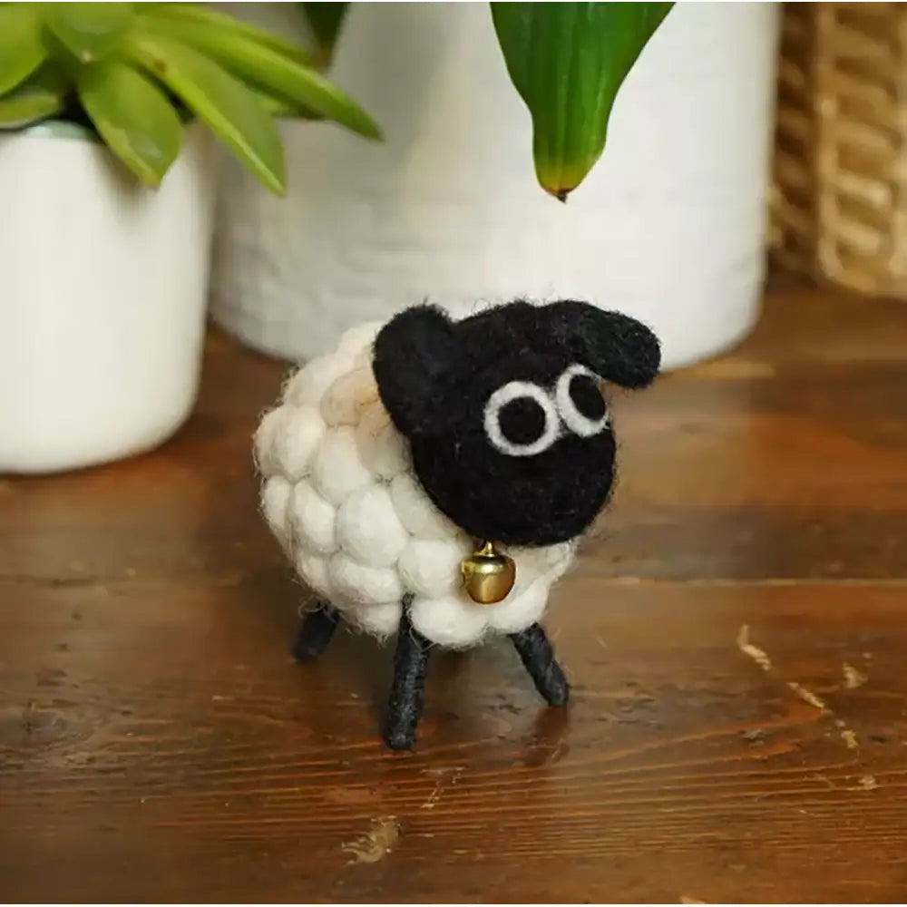 Black faced felted sheep with a bobbly white body. 