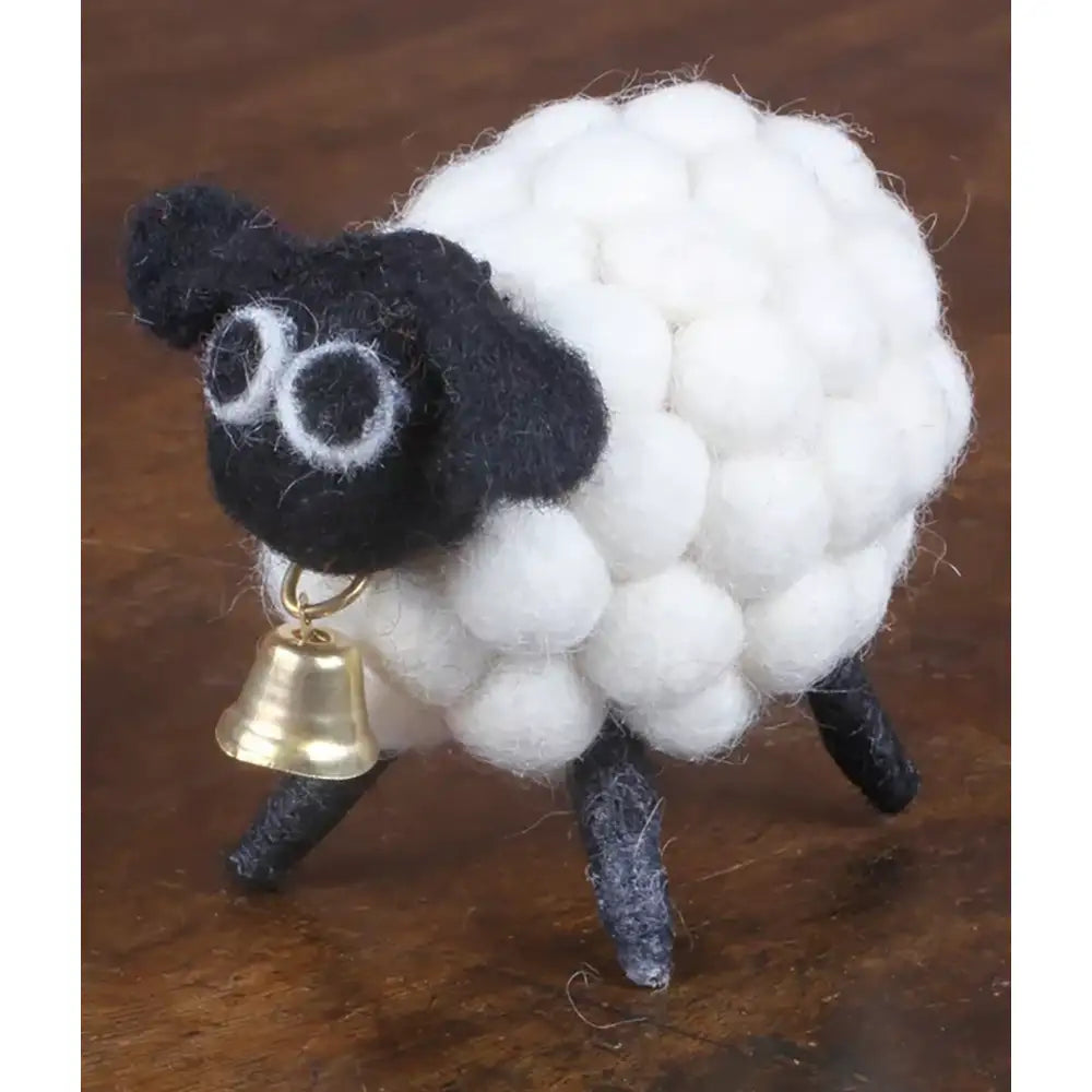 Felt sheep with a black face and bobbled white coat. Golden bell under chin.