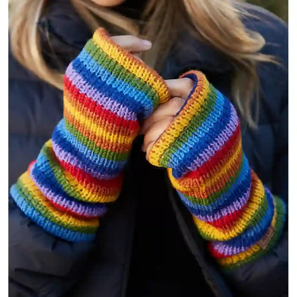 A person wearing a pair of long, rainbow-striped knit fingerless gloves or wrist warmers over a dark puffer jacket.