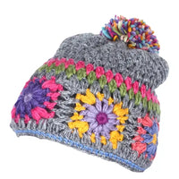 Colorful crocheted beanie with a pom-pom on a white background