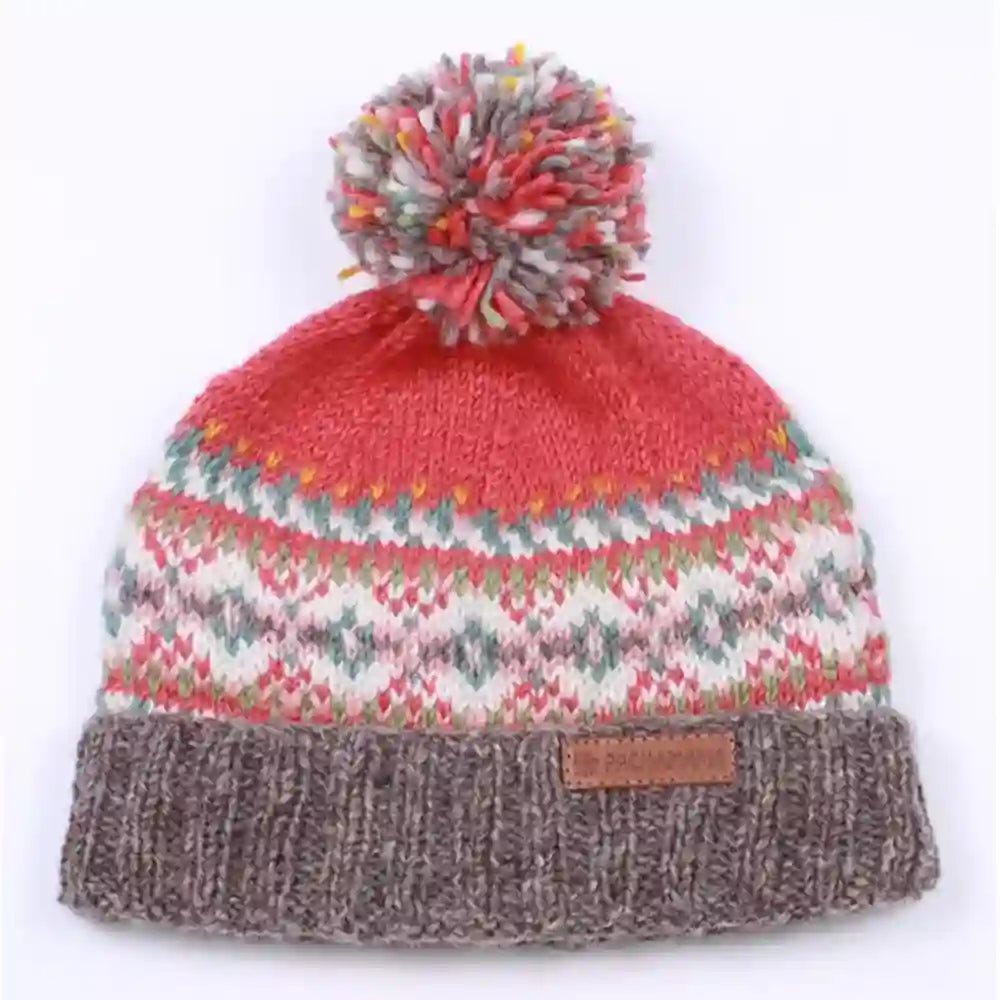 A multicolor knit beanie hat featuring a coral red top section, a white and pink Fair Isle patterned middle section, and a ribbed brown cuff with a small brown leather patch. It is topped with a matching multicolor pom-pom.