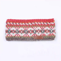 A knitted headband with a multicolor Fair Isle pattern of red, green, gray, and white, featuring a small brown leather brand patch on the front.